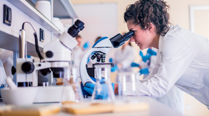 Researcher looking through microscope