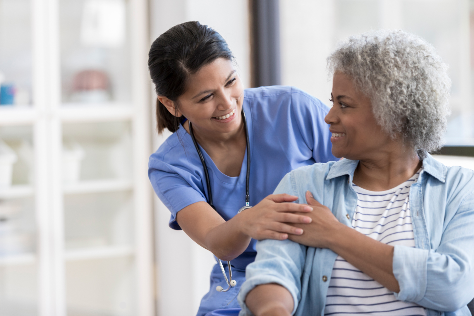 Friendly healthcare professional reassuring middle aged patient