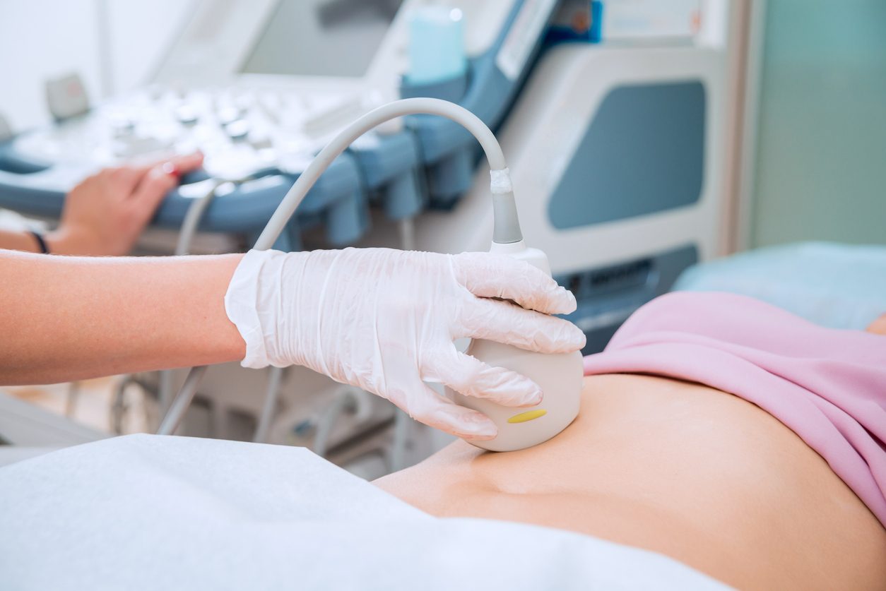 Doctor using an ultrasound scanner on a patient's stomach