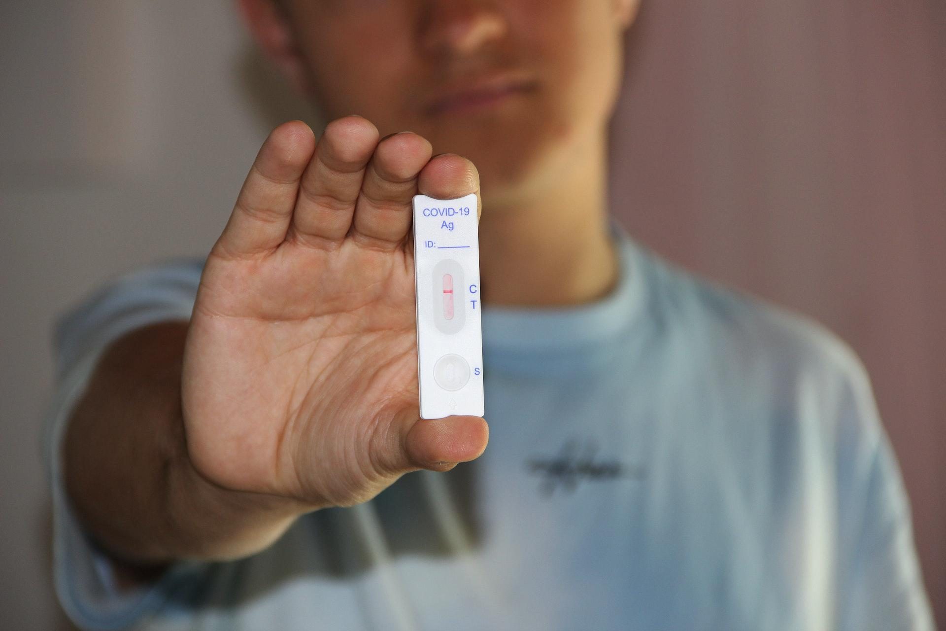 Young man holding COVID test