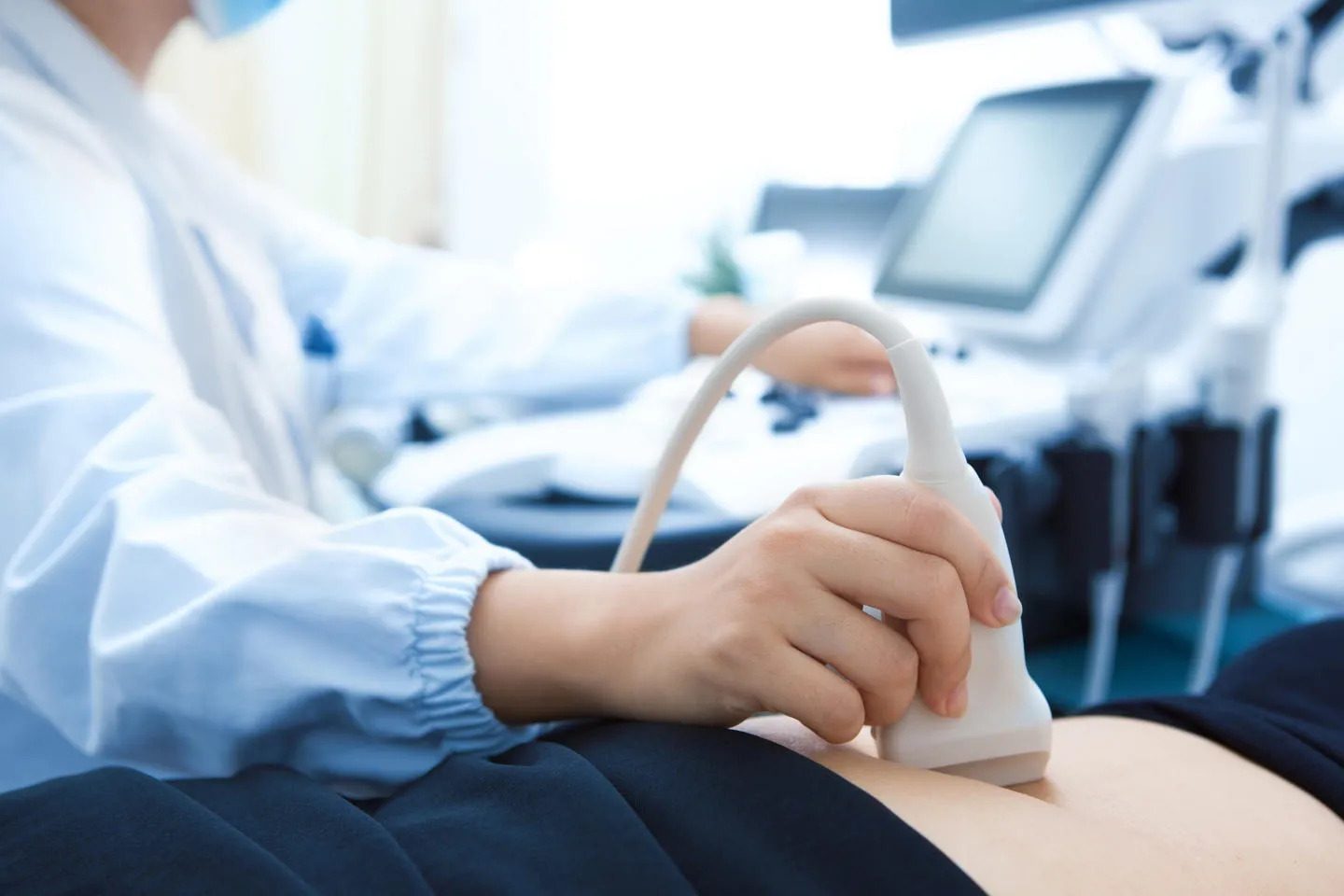 Health professional carrying out ultrasound on a patient's stomach