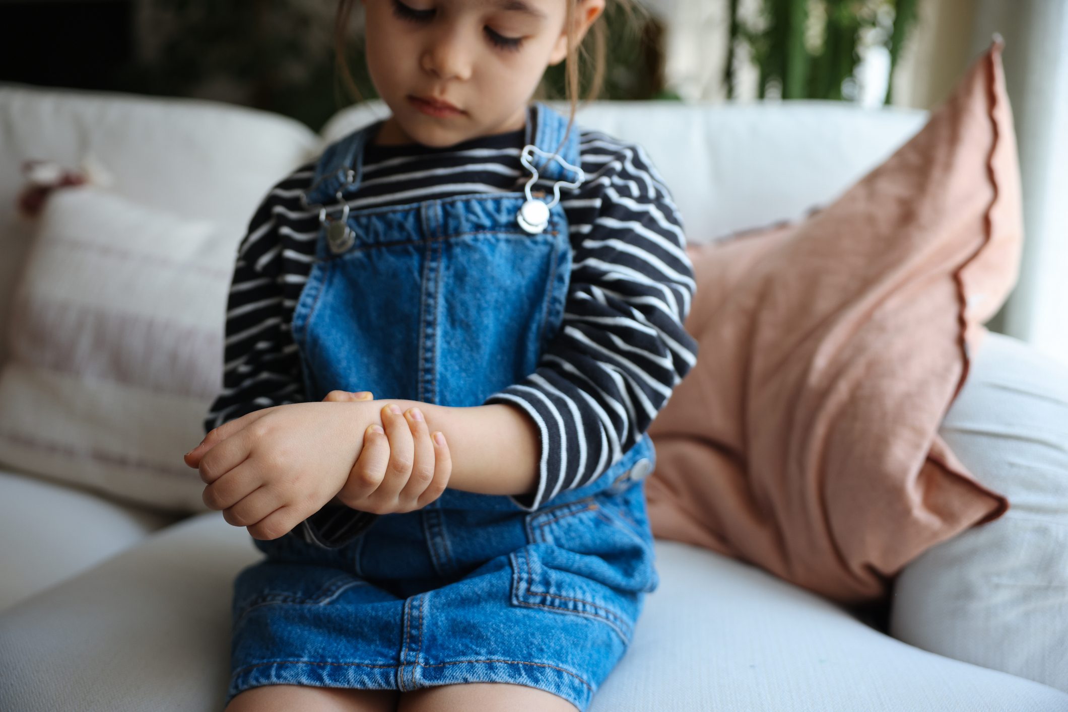 Child with arthritis holding her painful wrist