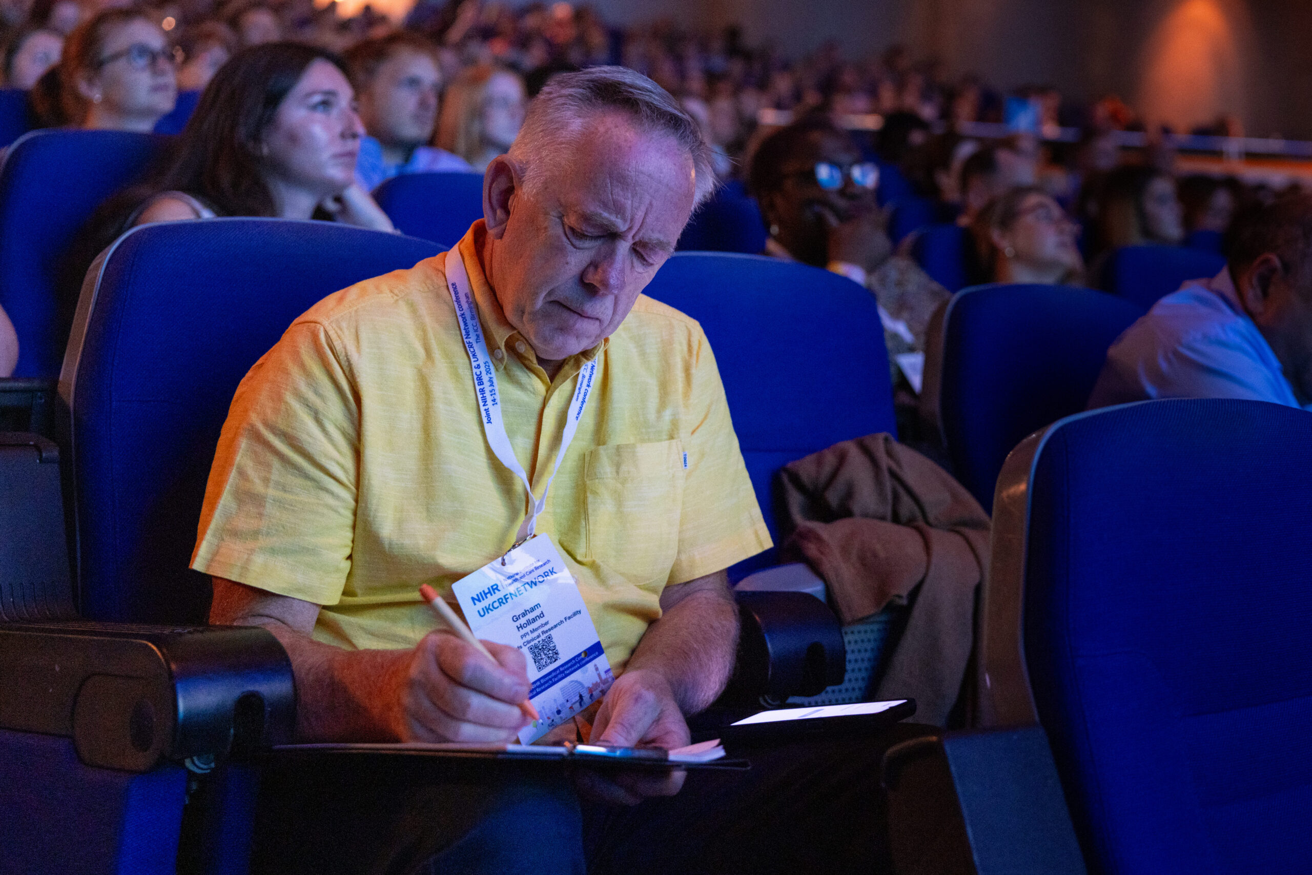 Attendee taking notes during plenary talk