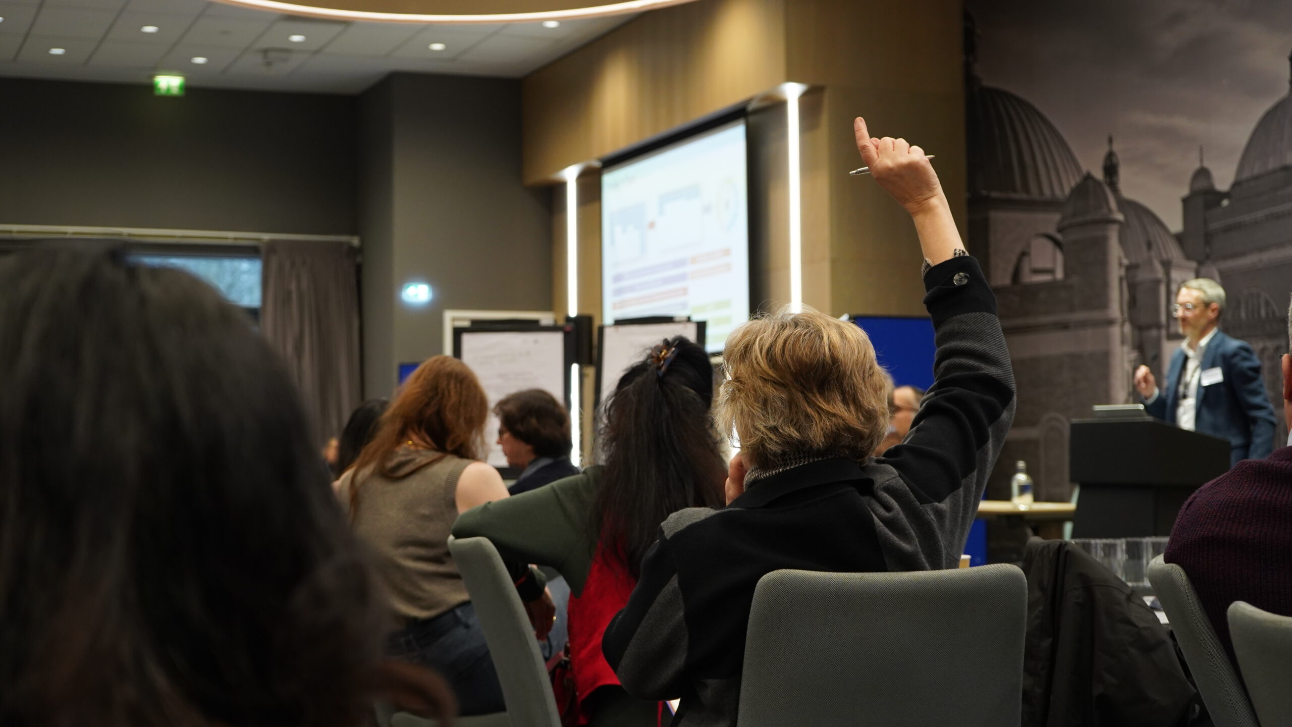 Attendee with raised hand to ask question